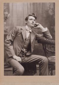 Young Mathias J. Alten seated with suit, head resting on hand, and looking away from viewer