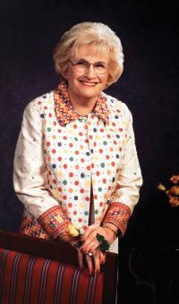 Barbara A. Gordon standing in front of chair with polka dot jacket